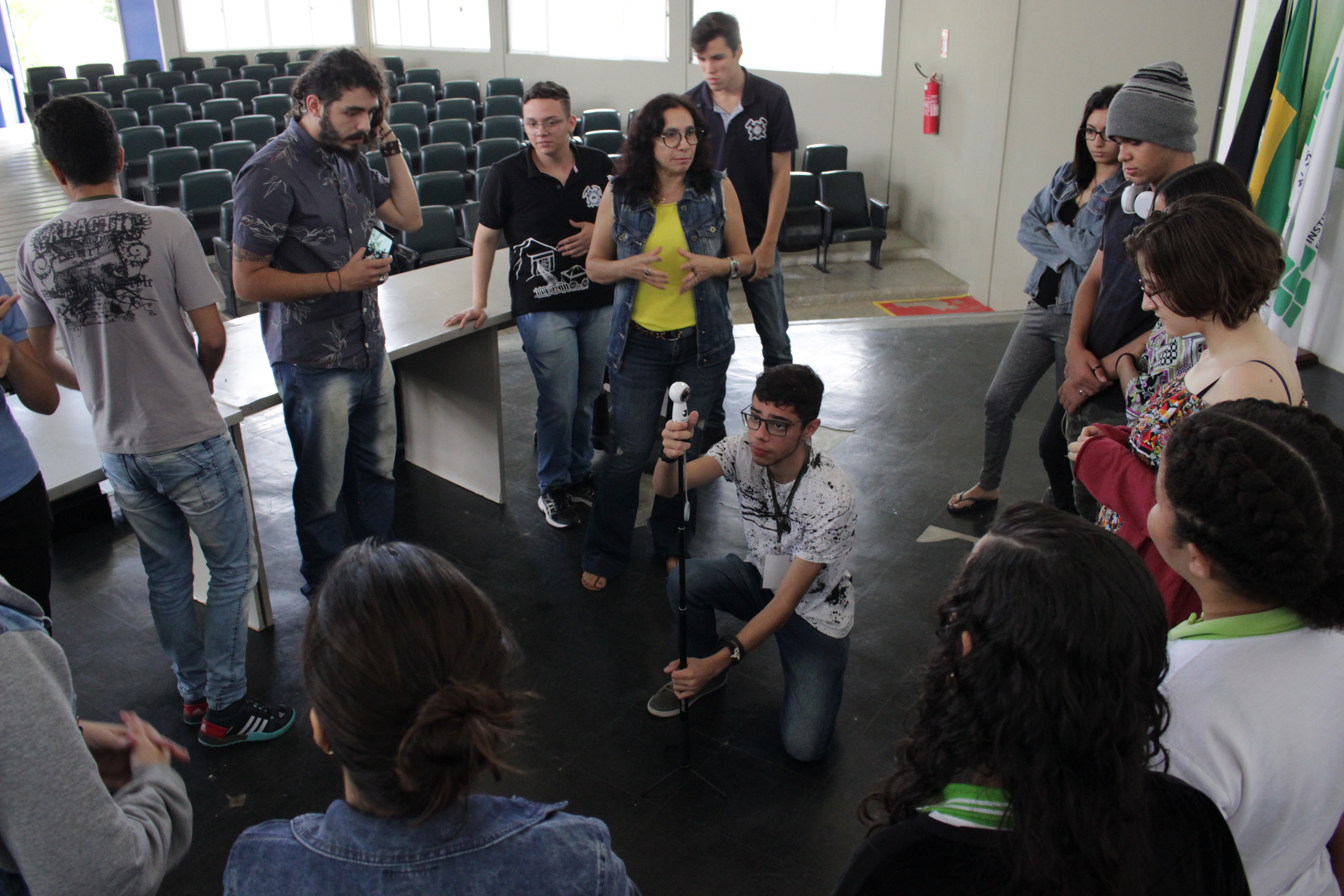 Na foto, o produtor cultural Lucas de Faria,o segundo da esquerda para a direita em pé e a professora Gardênia orientando estudantes  