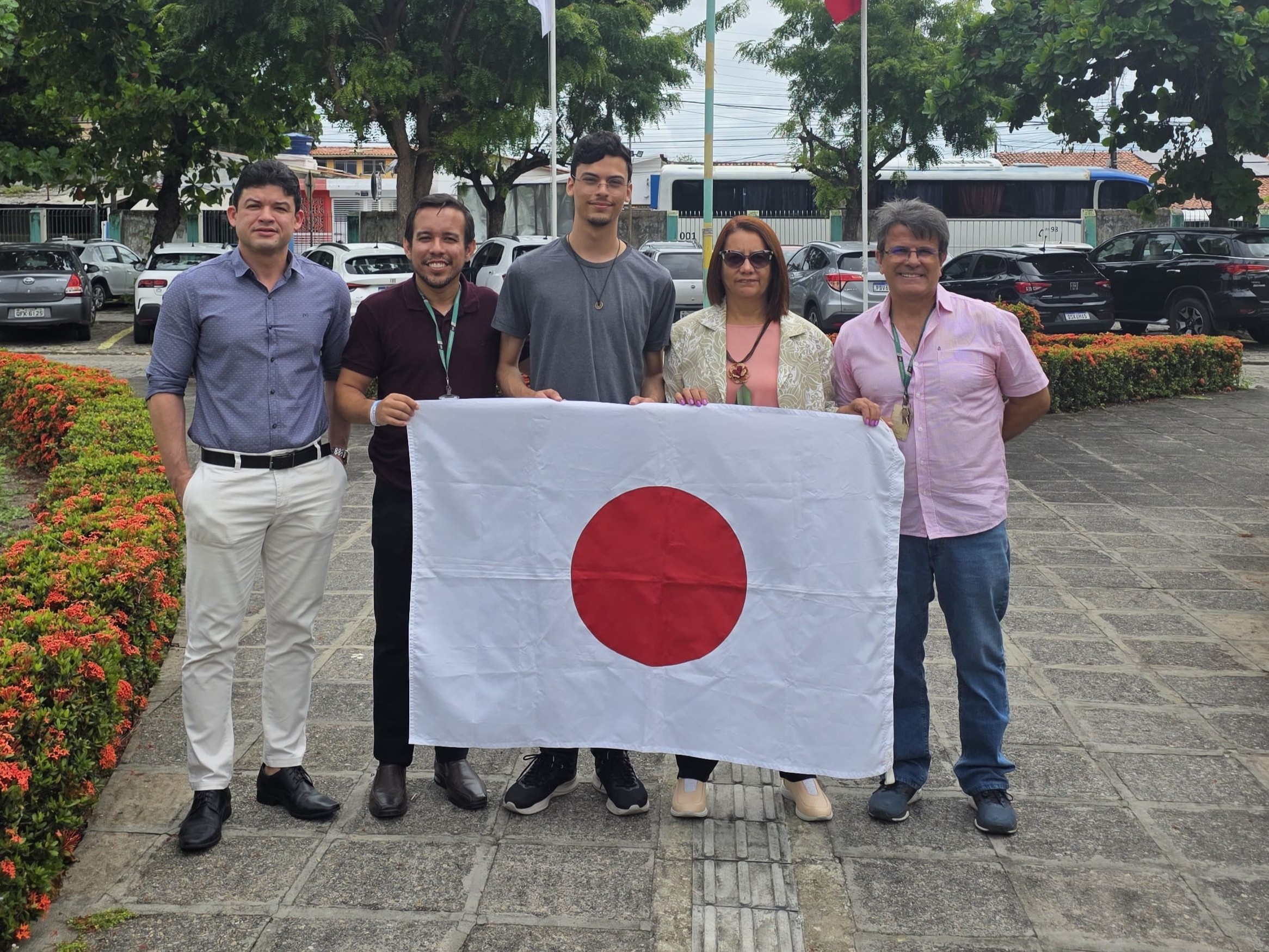 Com Sammuel, no Jardim do campus, na frente das bandeiras.jpeg